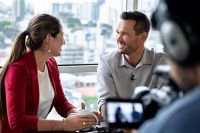 man and woman talking on camera